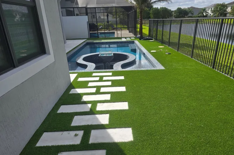 Pool with a round raised spa and stepping pavers in turf