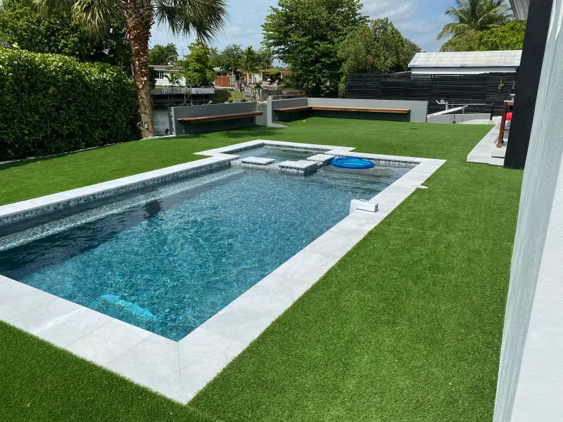 Modern pool and spa surrounded by artificial turf