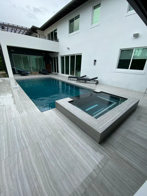 Modern pool with a raised spa and a wood-look porcelain deck