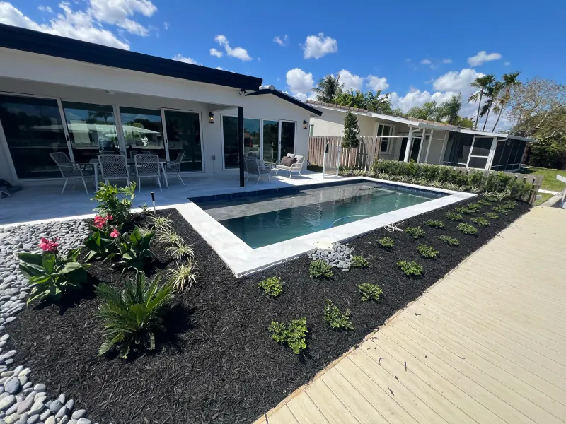 Canal-front pool with a marble deck and fresh landscaping