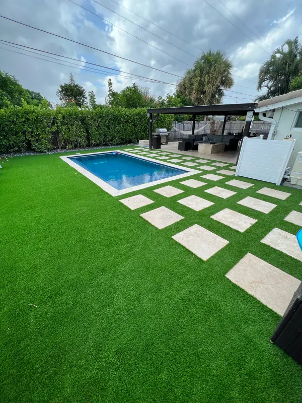 Small pool with stepping pavers in an artificial-turf yard