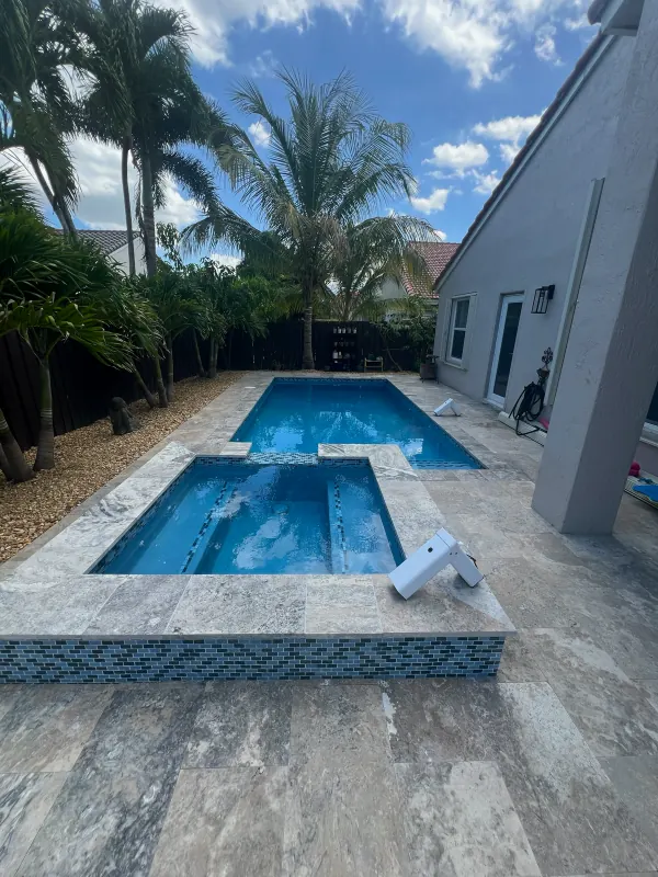 Pool with a raised spa finished in glass mosaic tile