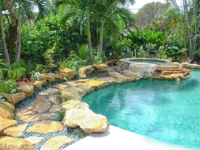 Lagoon pool with natural rock edging, raised spa and lush landscaping