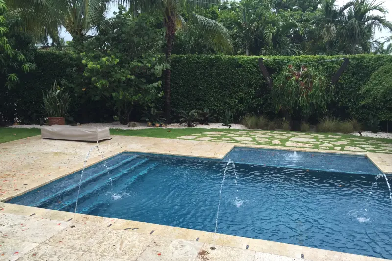 Geometric pool with deck jets and a tiled spa