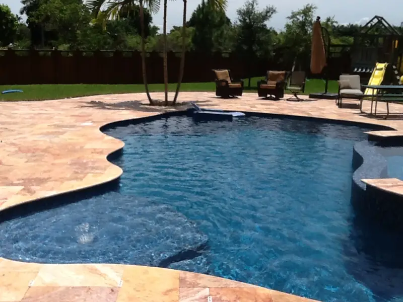 Freeform pool with a travertine deck