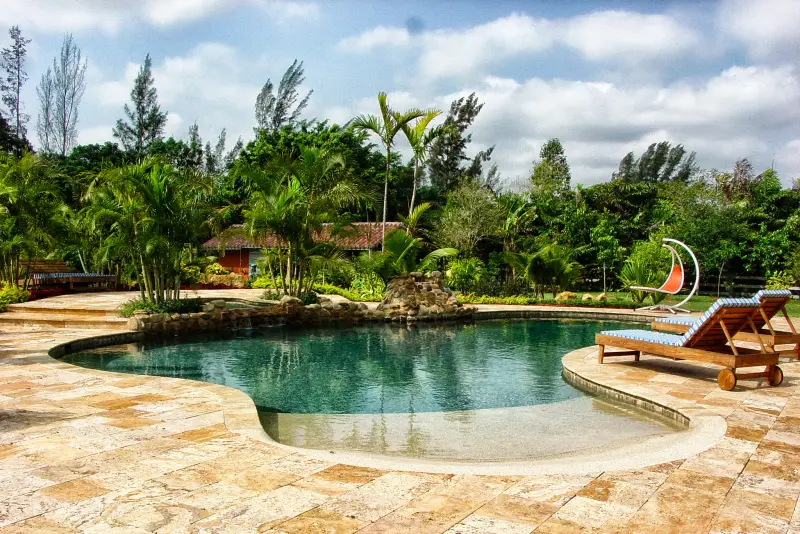 Freeform lagoon pool with sun shelf and travertine deck