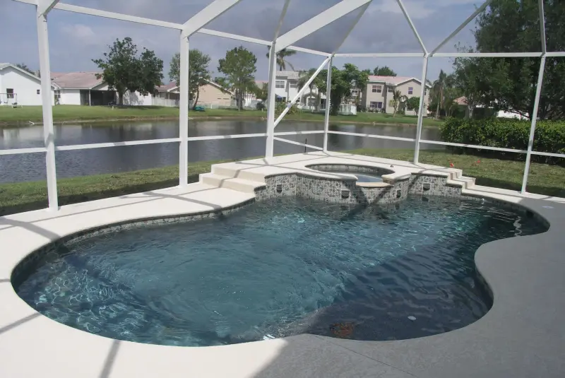 Screened freeform pool and spa on the lake