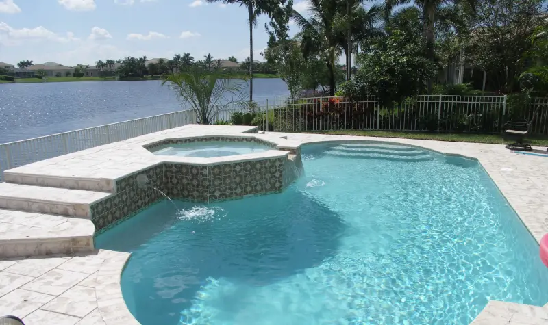 Freeform pool with raised spa by the lake
