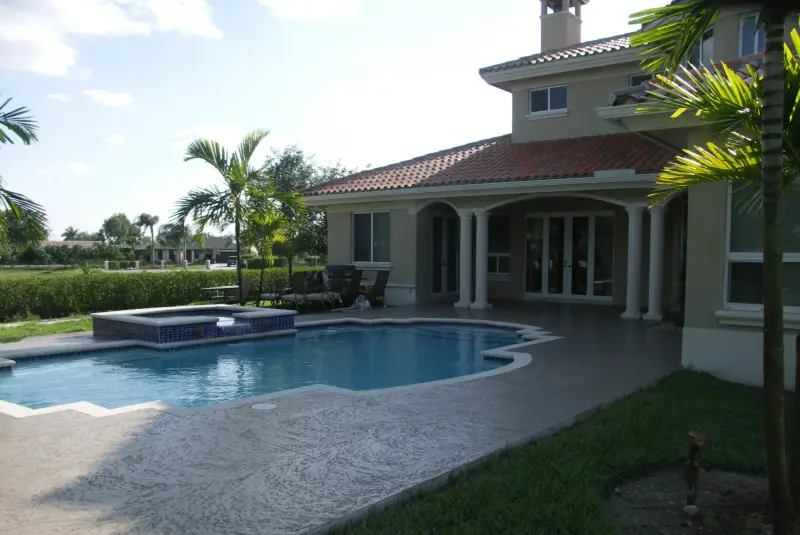 Freeform pool behind a Mediterranean-style home